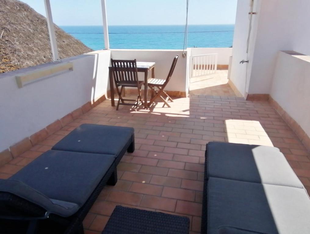 a patio with a table and chairs and the ocean at Mandala Bungalows - Adults Only in Los Caños de Meca