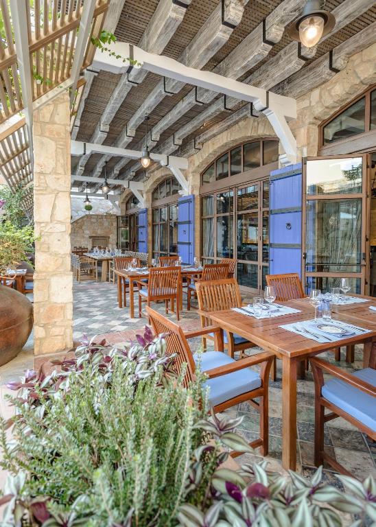 an outdoor patio with wooden tables and chairs at Columbia Beach Resort in Pissouri