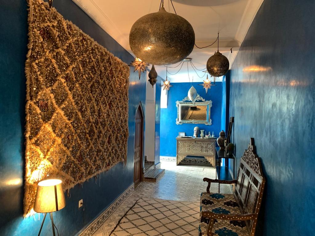 a hallway with blue walls and a table in a room at Riad Yamina in Marrakesh