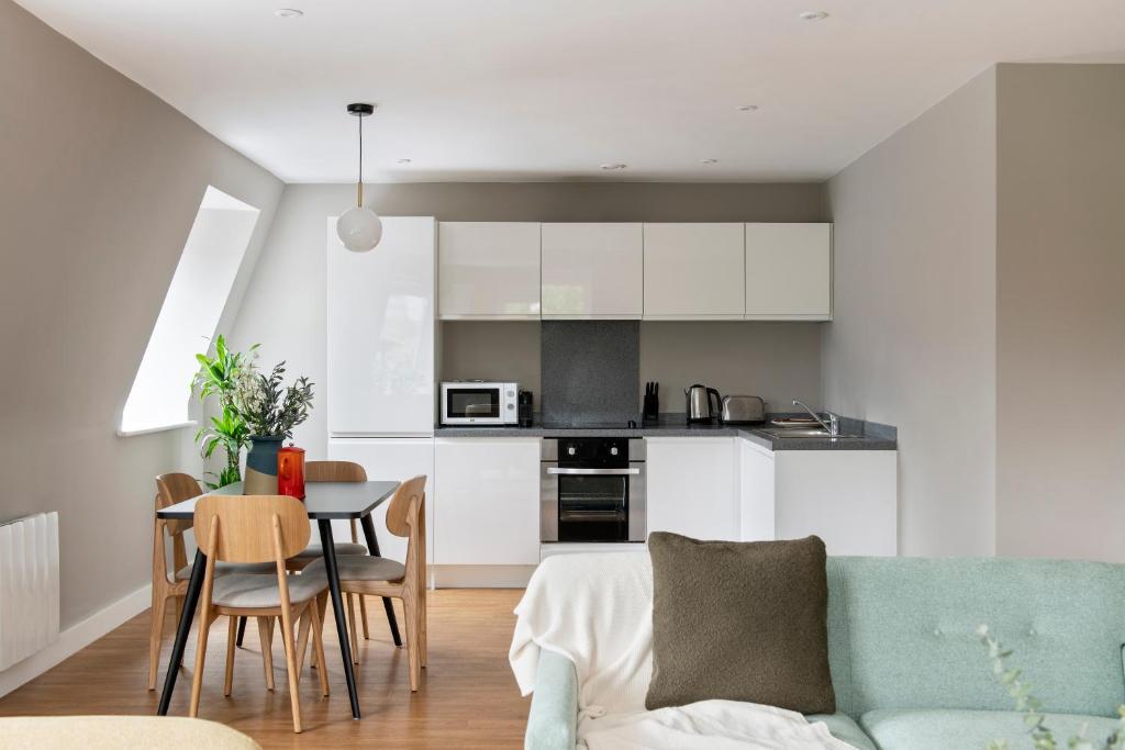 a kitchen and dining room with a couch and a table at Cove Minshull Street in Manchester