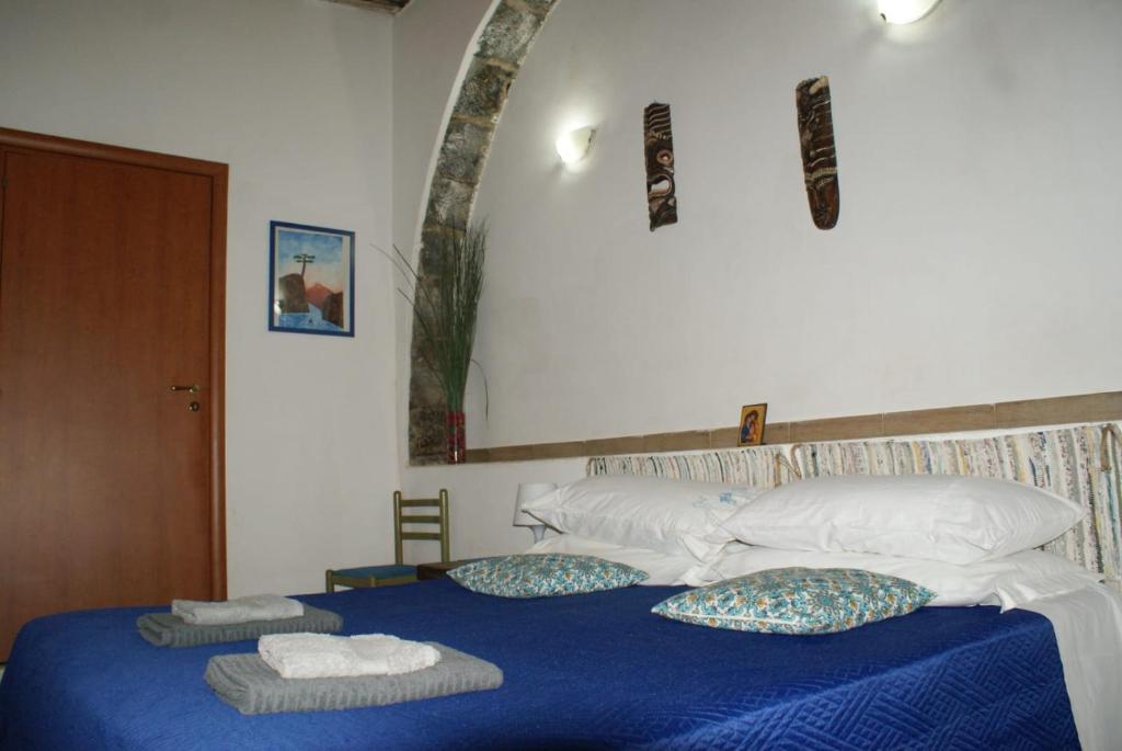 una camera da letto con un letto blu e asciugamani di La piazzetta a Linguaglossa