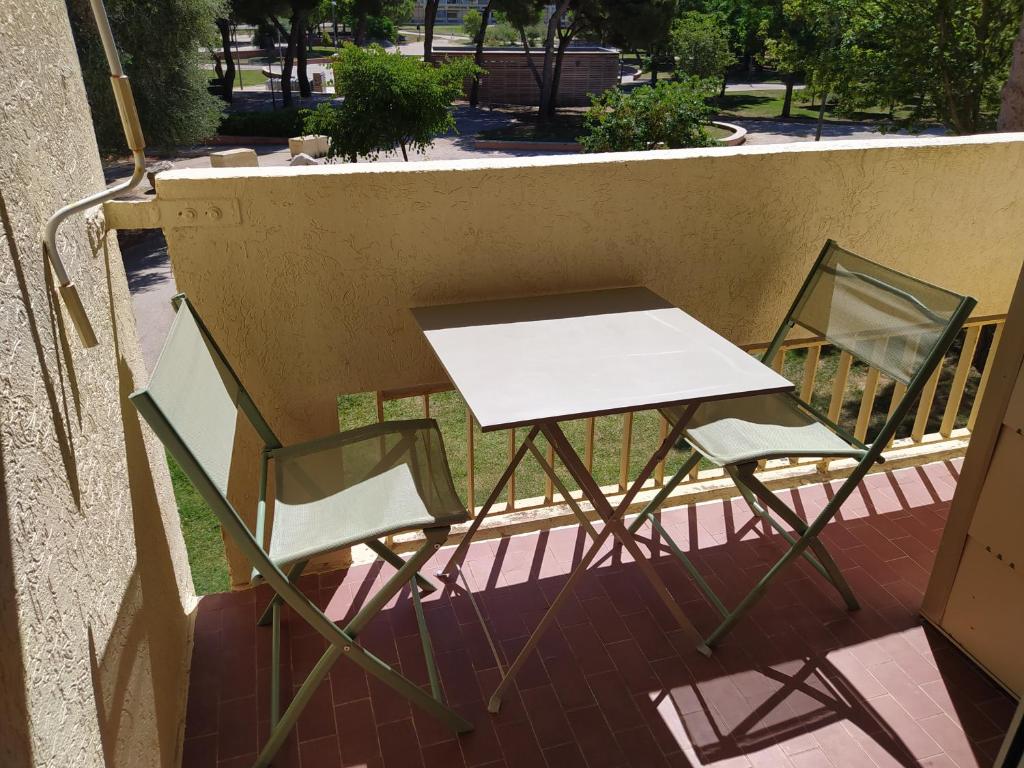two chairs and a table on a balcony at charmant studio à Balaruc les bains in Balaruc-les-Bains