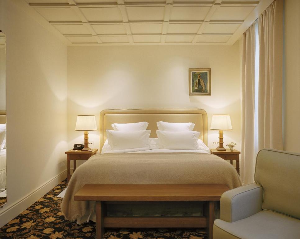 - une chambre avec un lit, deux lampes et une chaise dans l'établissement Château Voltaire, à Paris