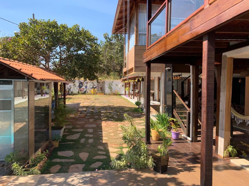 een lege loopbrug tussen twee gebouwen met planten bij Pousada Hibiscos in Serra do Cipo