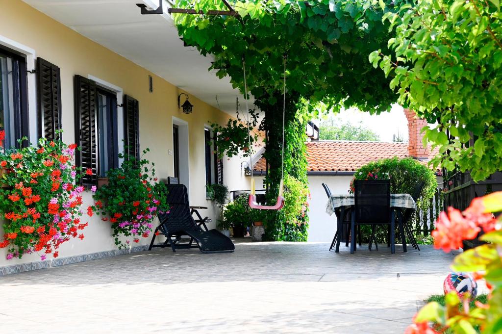 a courtyard with a table and chairs and flowers at Apartma Čuk in Dutovlje