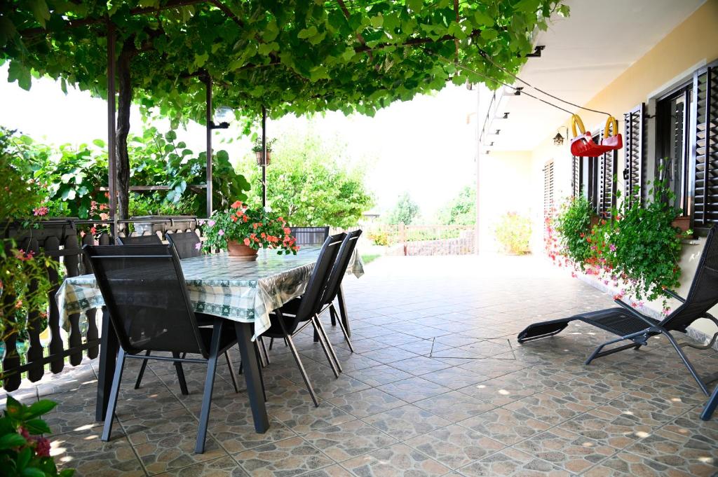 a patio with a table and chairs on a patio at Apartma Čuk in Dutovlje