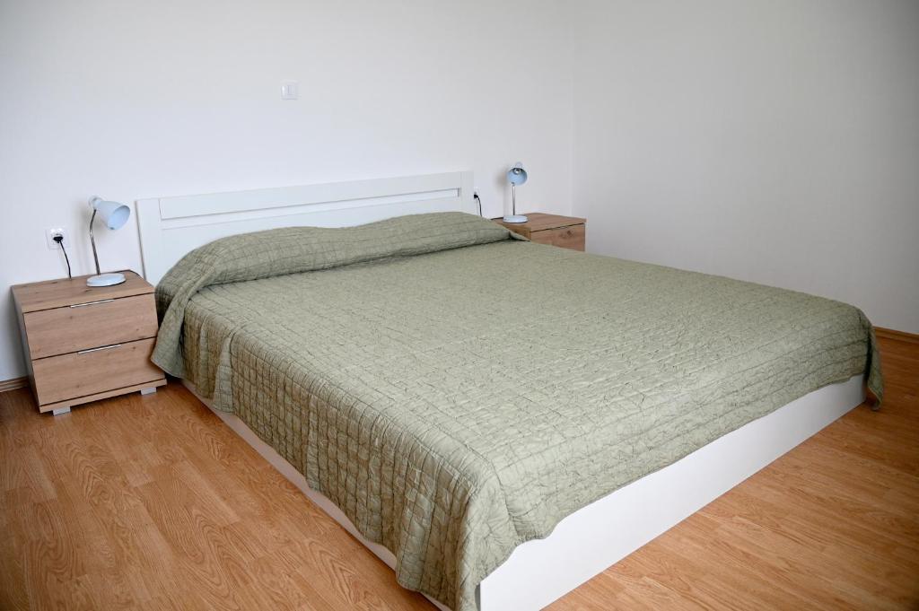 a bedroom with a bed and a night stand with two lamps at Apartma Čuk in Dutovlje