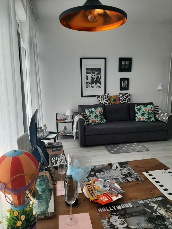 uma sala de estar com um sofá e uma mesa em Hollywood Apartament Piotrkowska Klimat,Jakość,Styl em Lódź