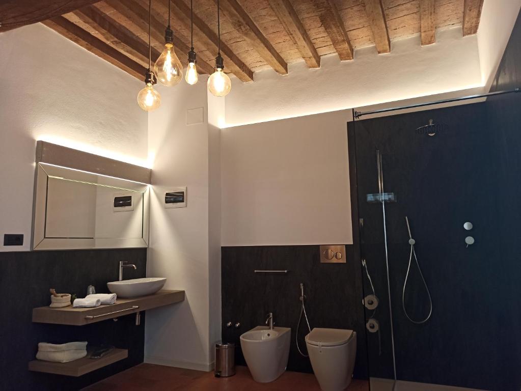 een badkamer met 2 toiletten, een wastafel en een douche bij La Corte Dei Sogni B&B in Modena