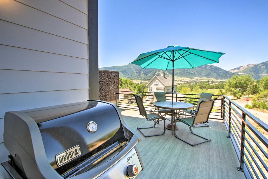 - un balcon avec une table et un parasol dans l'établissement Modern Mtn View Townhome Less Than 5 Mi to Skiing!, à Eden