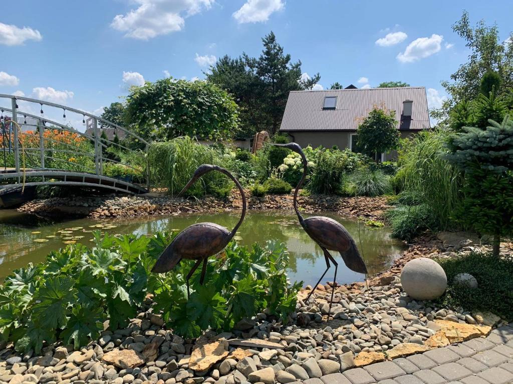 dos estatuas de aves en un estanque en un jardín en Siedlisko Przyjazne Progi en Rusocice
