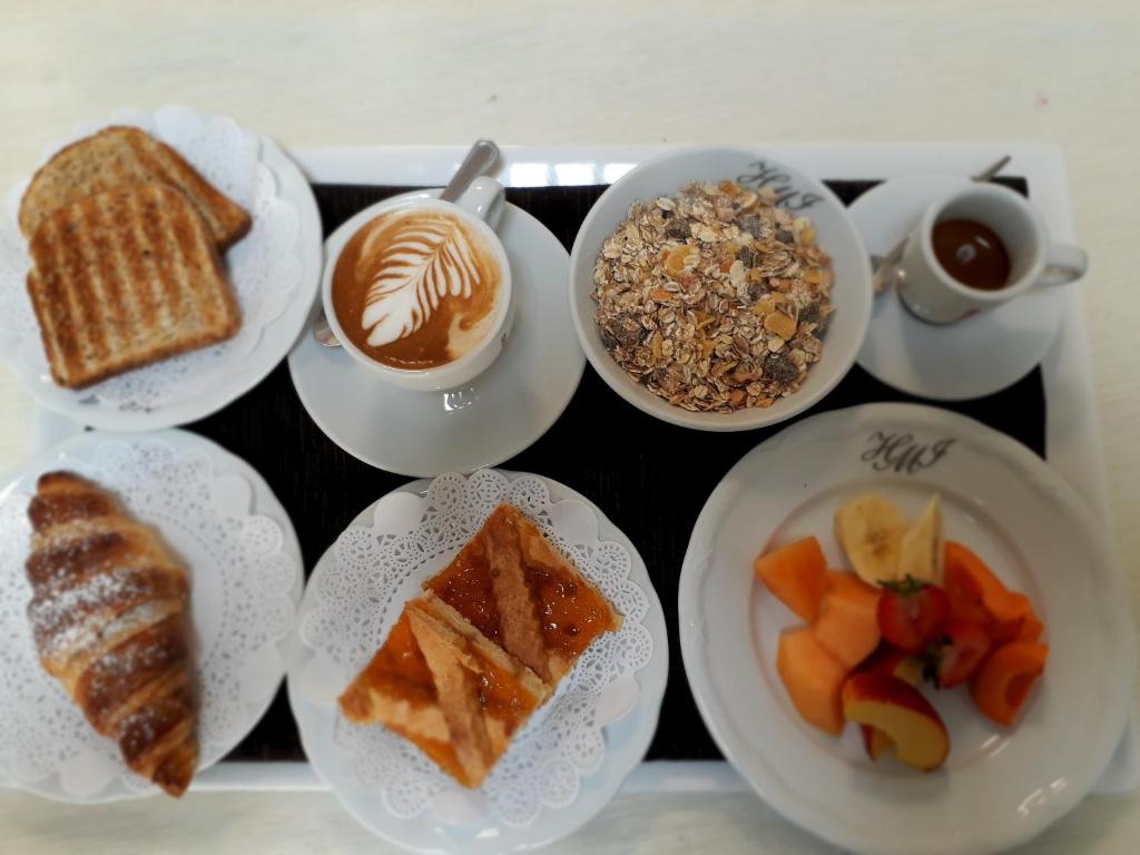 a tray with plates of food and cups of coffee at Hotel Mirasole International in Gaeta