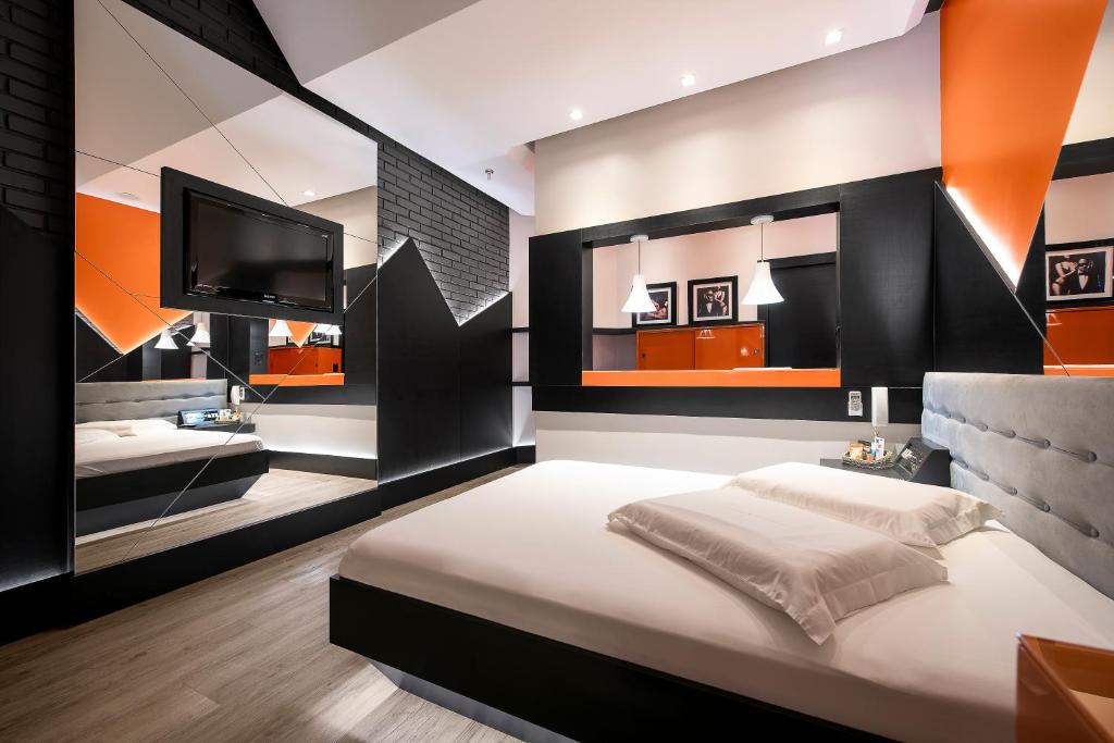 um quarto com uma cama grande e uma televisão de ecrã plano em Monn Cherry Motel em Lajeado