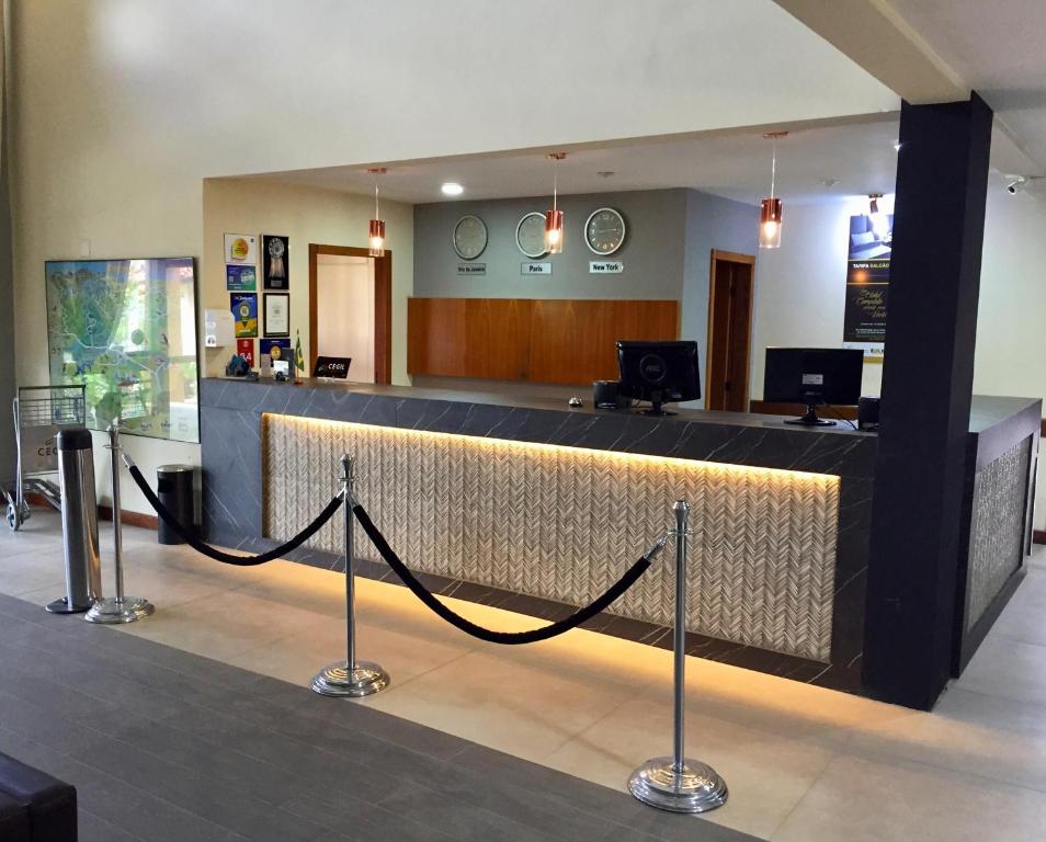 a lobby with a reception counter with a black rope at Cegil Hotel Boulevard in Resende