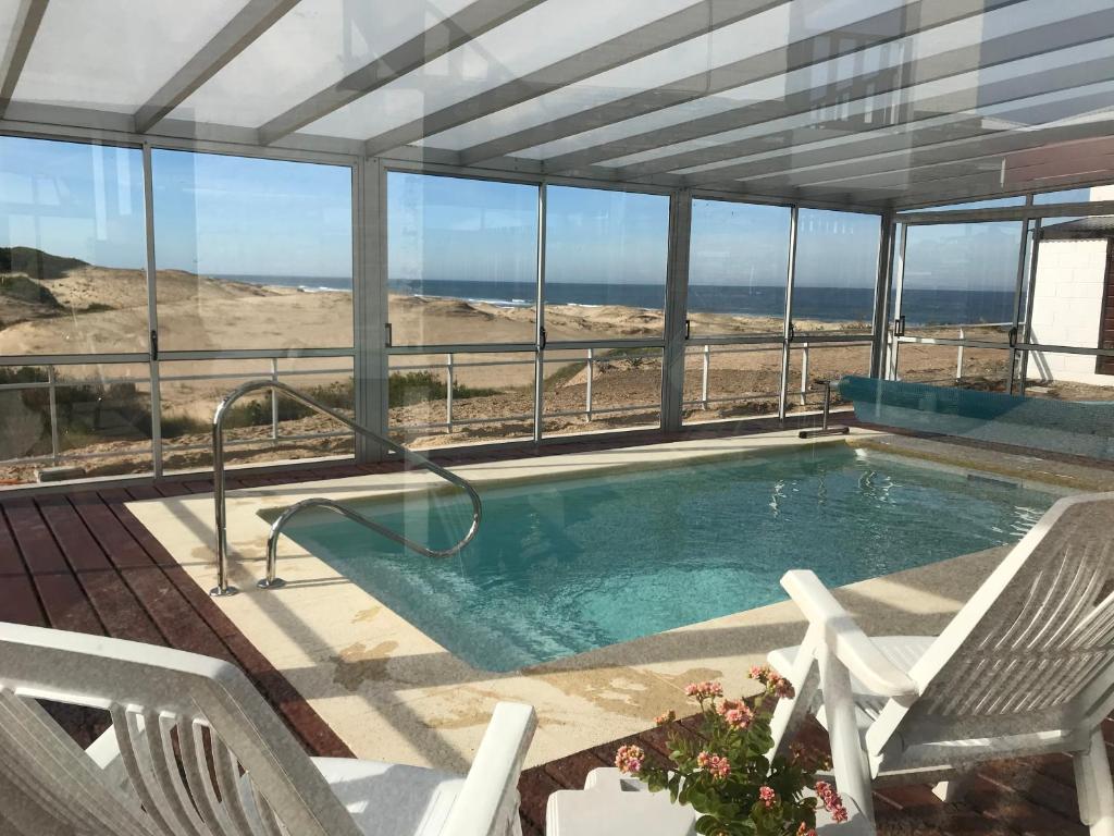 a swimming pool with a view of the beach at El Diablo Chic Colonial in Punta Del Diablo