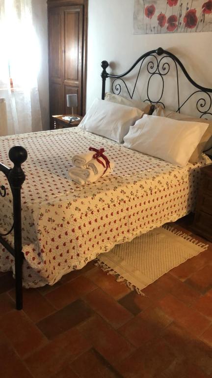 um quarto com uma cama grande com uma moldura preta em La casina in Via Fiorita em Montepulciano
