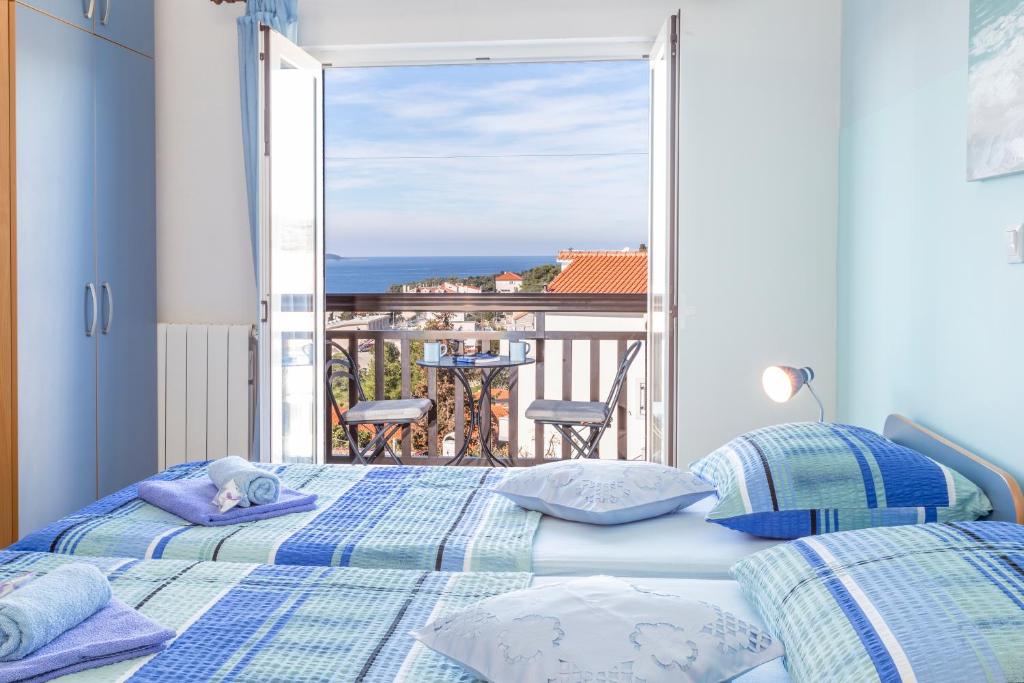 sypialnia z 2 łóżkami i widokiem na ocean w obiekcie Apartments Ivanović w Hvarze