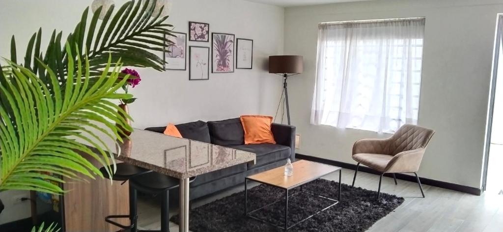 ein Wohnzimmer mit einem Sofa und einem Tisch in der Unterkunft 1 Apartaestudio Cedritos amplio in Bogotá