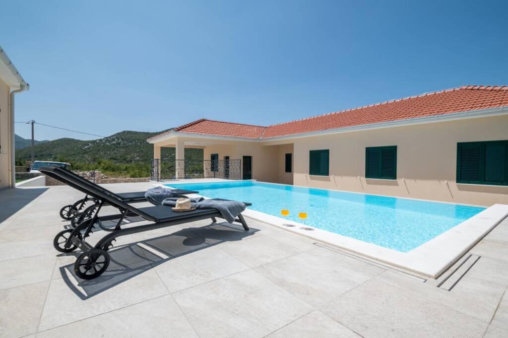 a swimming pool in the backyard of a house at LUXUS-VILLA mit 4 Schlafzimmern und POOL in der Nähe von Dubrovnik Kroatien und Bosnien in Ravno