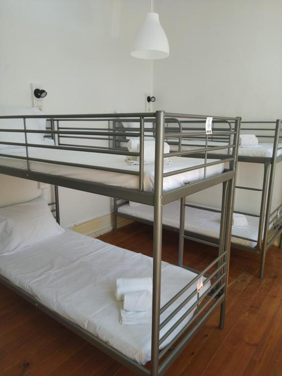 two bunk beds in a room with white towels at Baixa Terrace Hostel in Faro