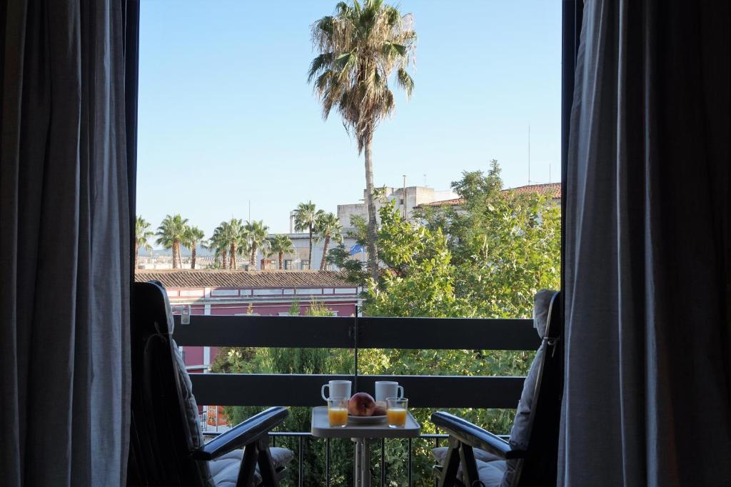 vista para uma palmeira a partir de um quarto de hotel em Apartamentos IMPLUVIUM Mérida em Mérida