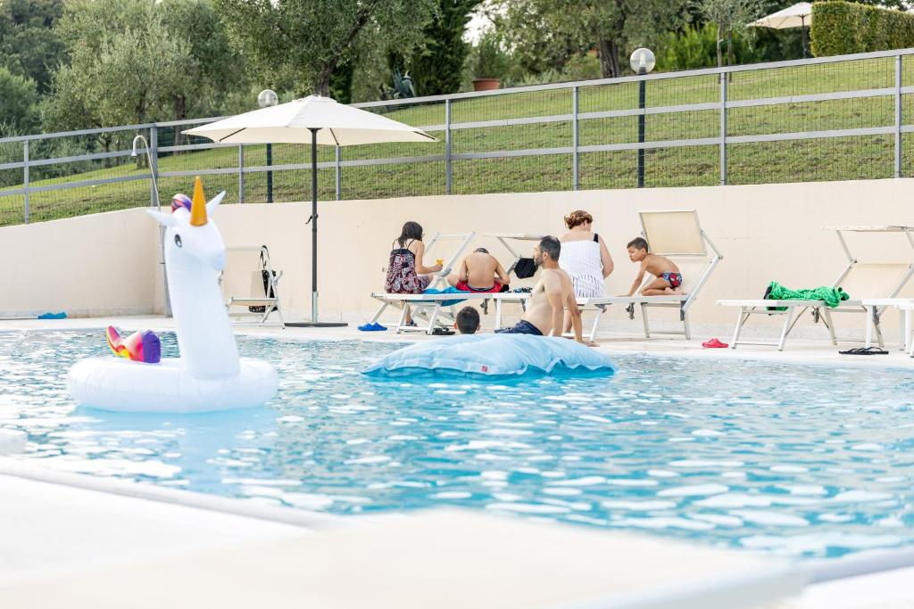 a pool with a unicorn and people in the water at Il Casale Lonato - by Host4U in Lonato del Garda