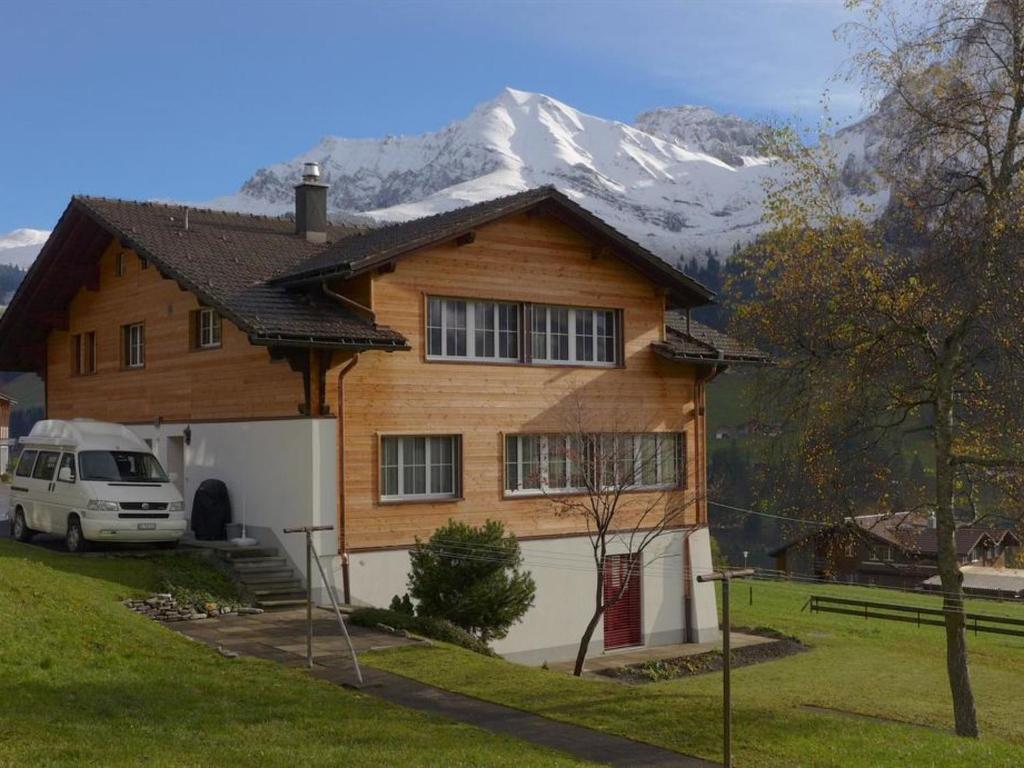 a house with a snow covered mountain in the background at Apartment Lucie by Interhome in Adelboden