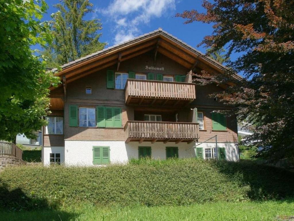 a building with a balcony on the side of it at Apartment Haldematt by Interhome in Adelboden
