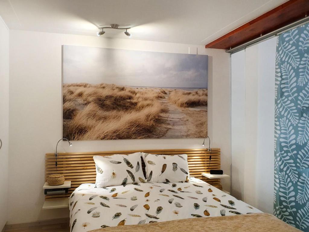 a bedroom with a bed with a painting on the wall at Apartment Open Space with Patio Lety by Interhome in Malvaglia