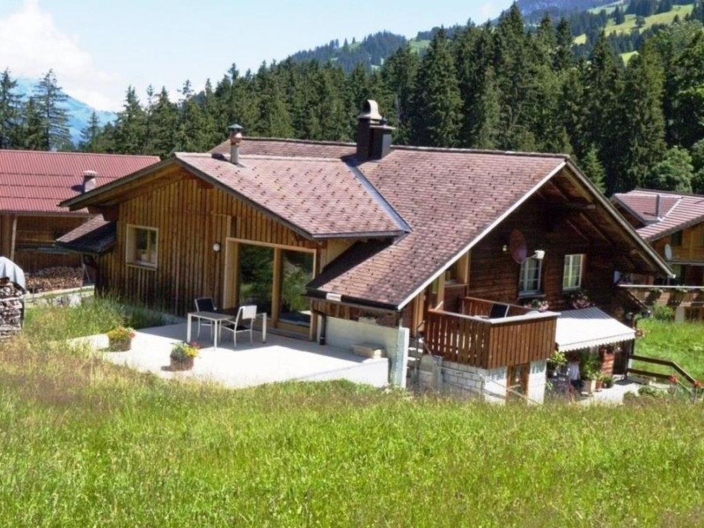 a log house with a porch and a deck at Apartment Burn- Alte Strasse by Interhome in Adelboden