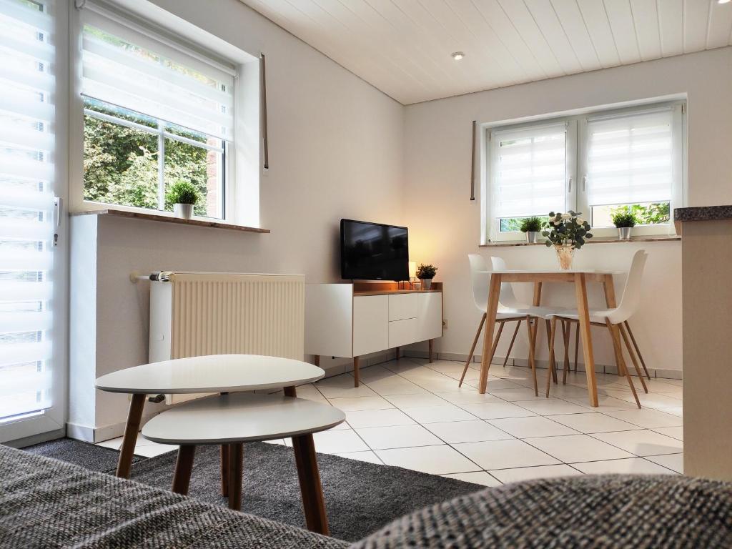 ein Wohnzimmer mit einem Tisch und einem TV in der Unterkunft Ferienwohnung Waldblick Teutoburger Wald in Oerlinghausen