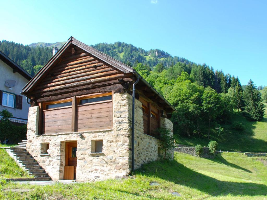 a stone house with a wooden door on a hill at Holiday Home Rustico Enrico by Interhome in Campo Blenio