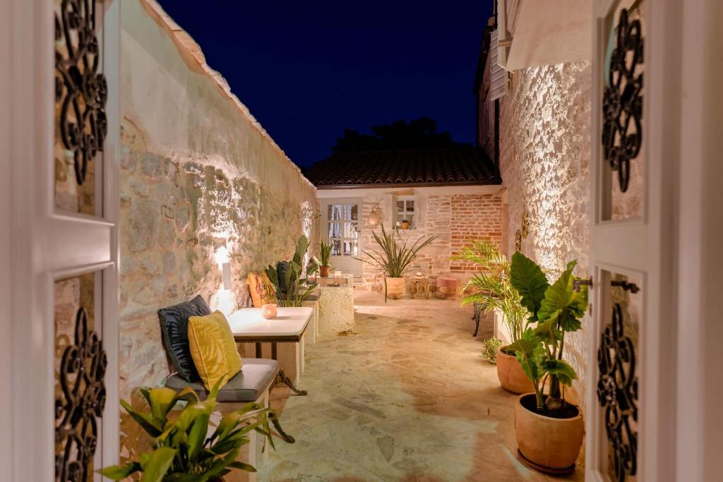 a courtyard with a table and potted plants at night at Town House Rosario in Stari Grad