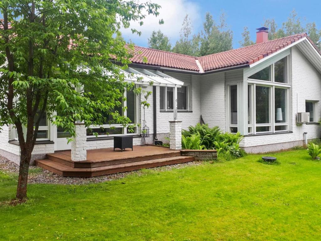 a house with a wooden deck in the yard at Holiday Home Polkurinne by Interhome in Saarijärvi