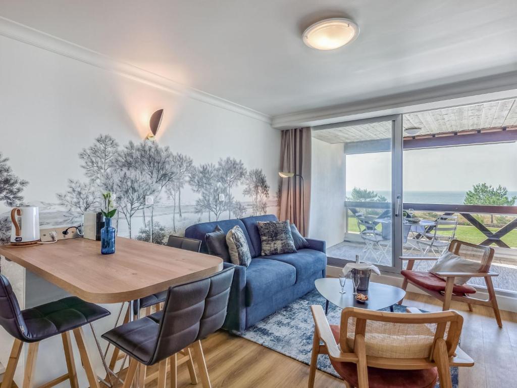 un salon avec un canapé bleu et une table dans l'établissement Studio Le Britannia-3 by Interhome, à Carnac