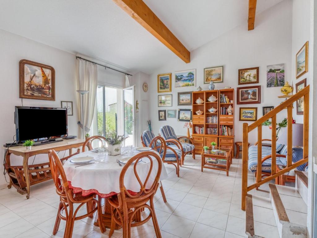 a dining room with a table and chairs and a television at Holiday Home Green Village-3 by Interhome in Roquebrune-sur-Argens