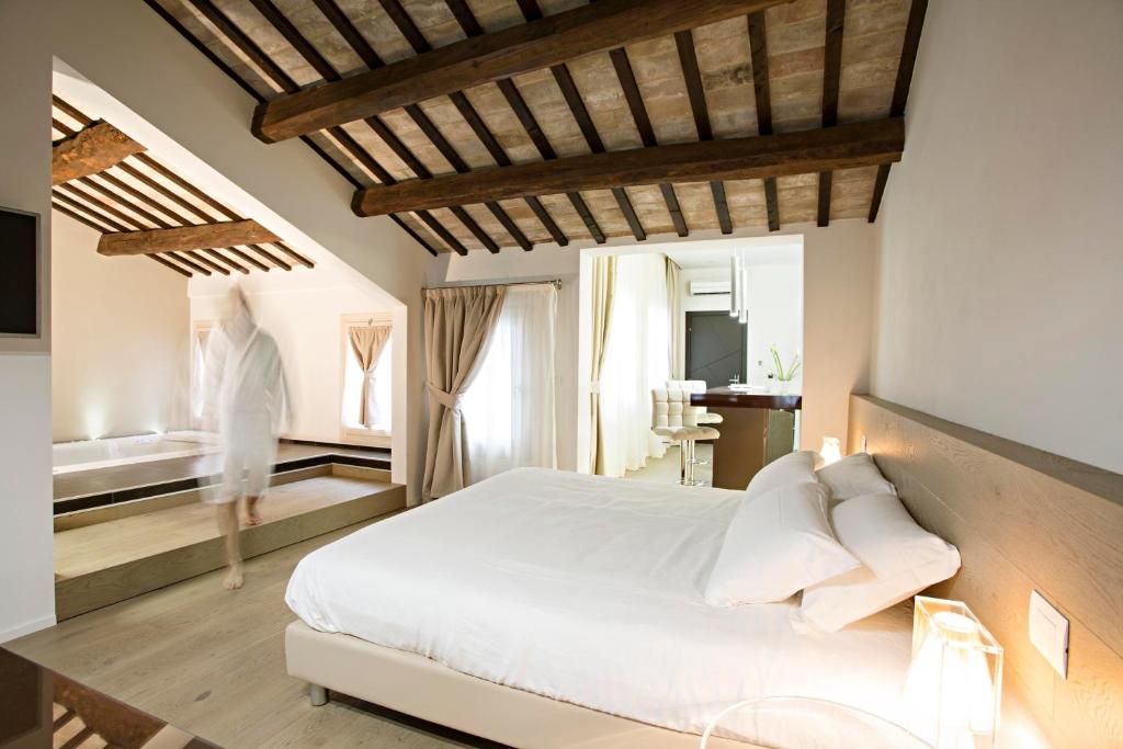 a bedroom with a large white bed and a mirror at Borgoleoni 18 - Room and Breakfast in Ferrara