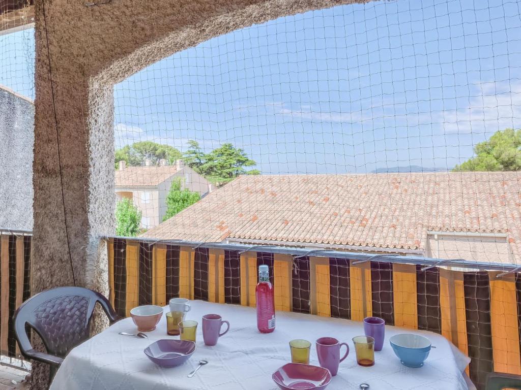 une table avec des tasses et des bols violets sur un balcon dans l'établissement Apartment Les Aigues Marines-62 by Interhome, à Saint-Cyr-sur-Mer