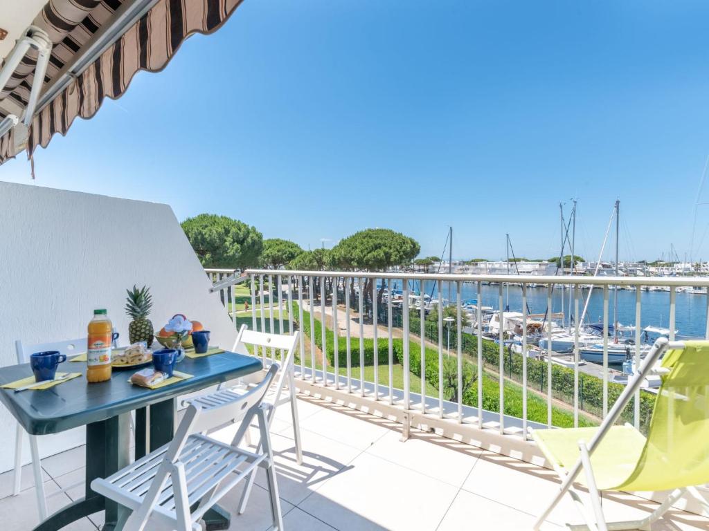 einen Balkon mit einem Tisch und Stühlen sowie einen Yachthafen in der Unterkunft Apartment La Santa Maria by Interhome in Le Grau-du-Roi