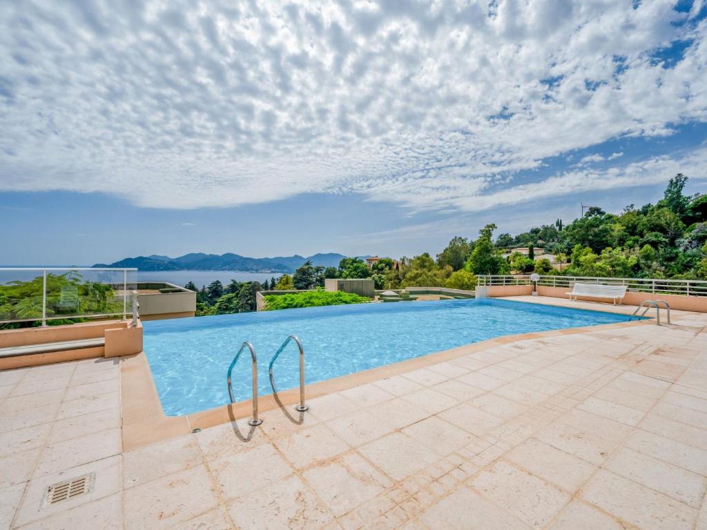 uma piscina numa villa com vista para a água em Apartment La Croix des Gardes by Interhome em Cannes