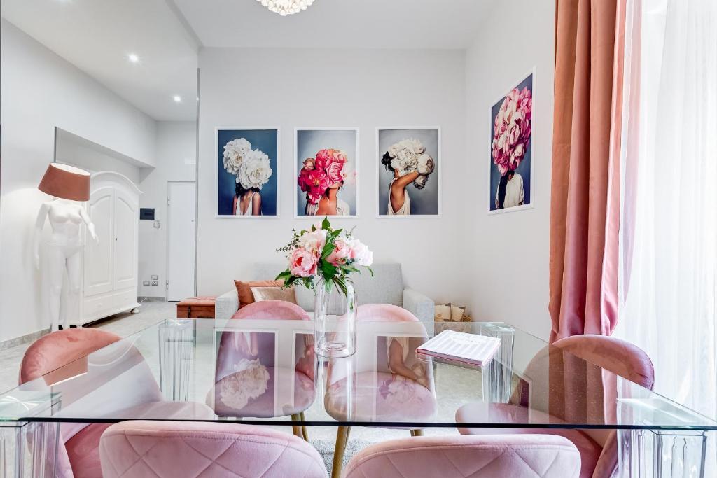 a dining room with a glass table and pink chairs at Trevi Fountain - NEW! - Your Italian Holidays in Rome