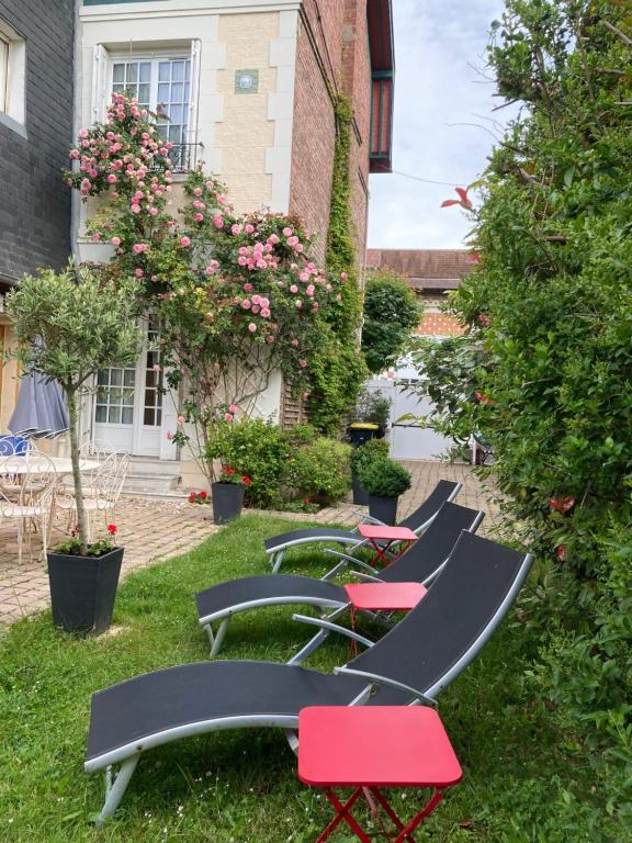 une rangée de chaises assises dans l'herbe dans l'établissement Le Mascaret, à Deauville