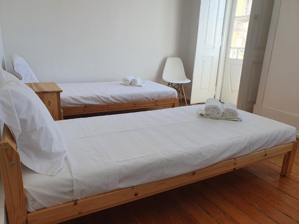 a bedroom with two beds with shoes on top of them at Baixa Terrace Hostel in Faro