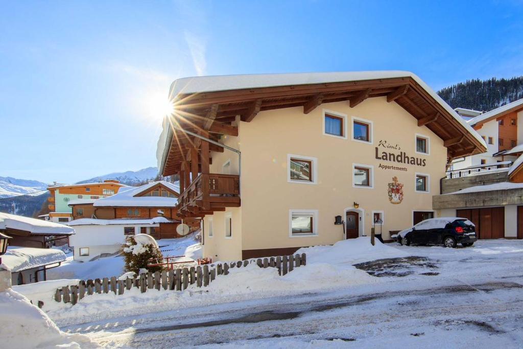 a large building with snow on the ground at Rimls Landhaus in Sölden