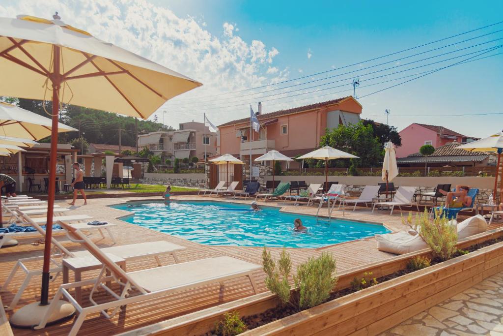 a pool with chairs and umbrellas in a resort at Nuevo Vista in Kavos