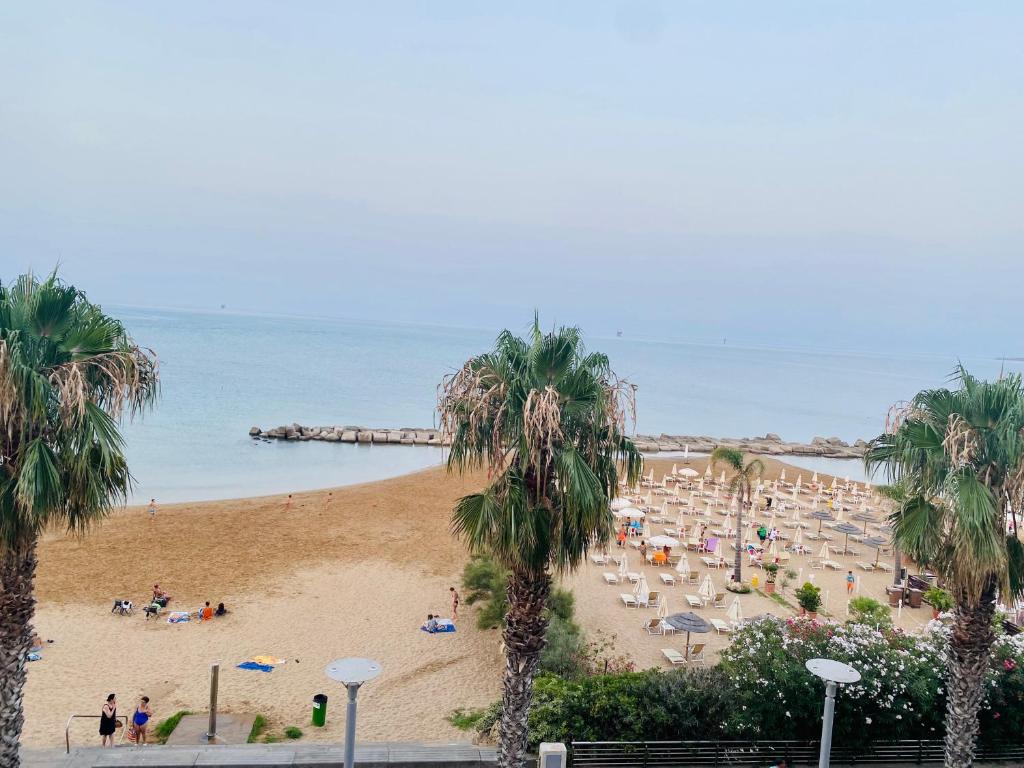 plaża z palmami i ludźmi na niej w obiekcie VISTA MARE w mieście Crotone