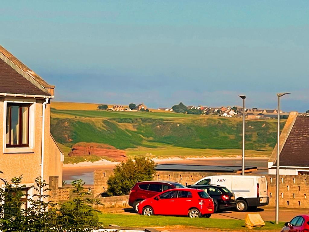 dois carros estacionados num parque de estacionamento ao lado de uma casa em Spacious 2 Bedroom Home in Picturesque Cullen em Cullen