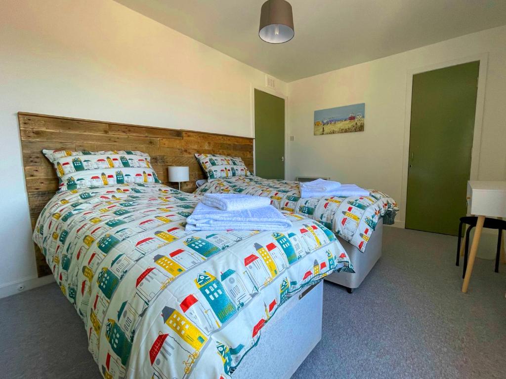 カレンにあるSpacious 2 Bedroom Home in Picturesque Cullenのベッドルーム1室(ベッド2台、木製ヘッドボード付)