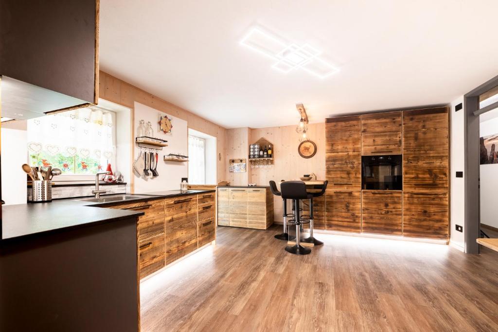 - une cuisine avec des murs en bois et un comptoir dans l'établissement Sa Mont Home - Moderno appartamento con giardino, sauna, barbecue, à Bellamonte