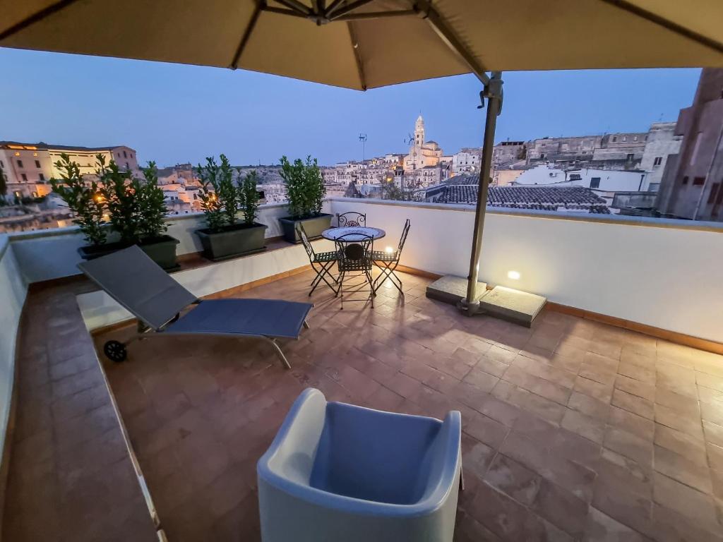 a balcony with a table and chairs and an umbrella at Antica Pepice in Matera